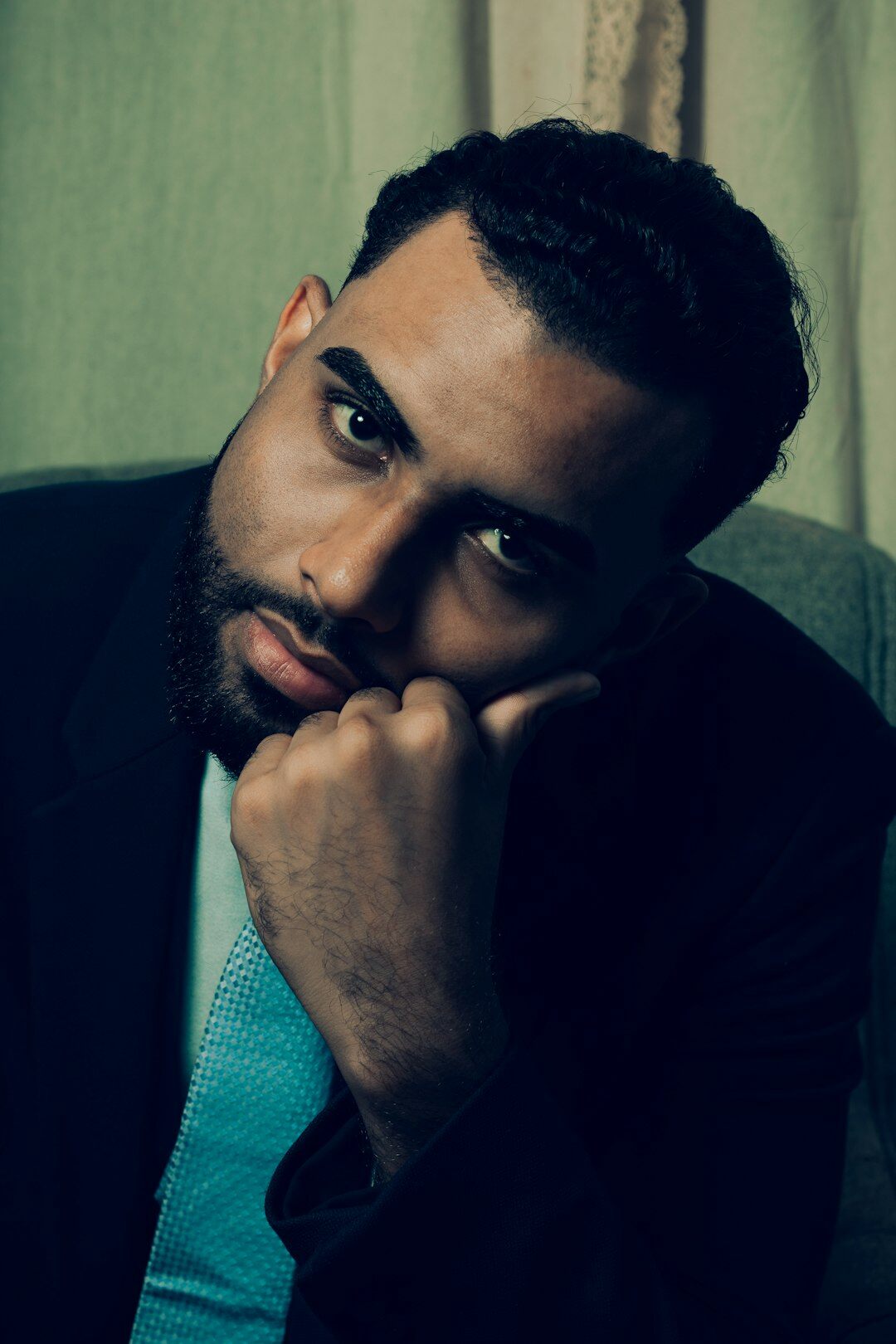 Studio portrait of a Black man with a short beard wearing a suit jacket