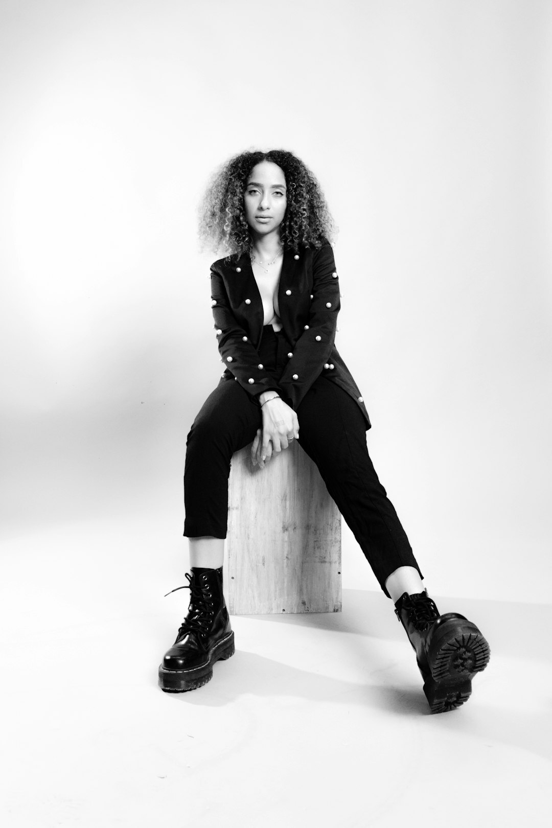 Studio portrait of a mixed race woman with curly hair wearing a blazer